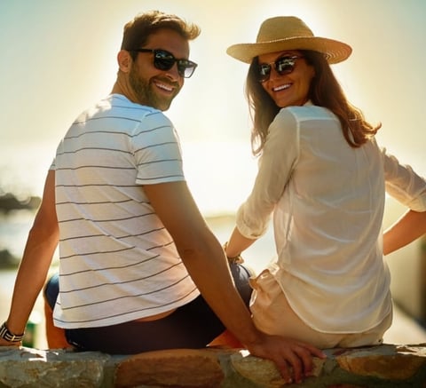 Una pareja sonriente disfrutando juntos al atardecer cerca del agua